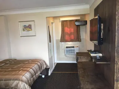 a hotel room with a bed and a television at Mayflower Motel in Kitchener