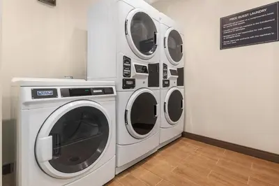three washing machines and a sign in a room at Candlewood Suites Collingwood by IHG in Collingwood