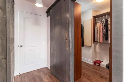 a hallway with a large wooden door in a room at Beautiful 3BR House in the Heart of Greek Town in Toronto