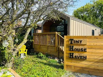 a tiny househaven sign in front of a house at Tiny House Haven in Peterborough