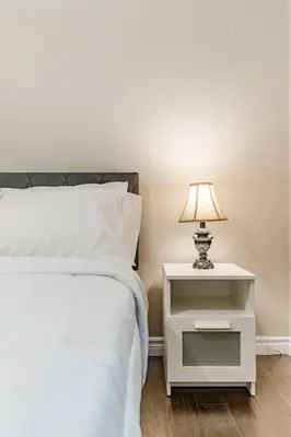 a bed with a night stand with a lamp on it at Fun & Cozy Retreat: Nature & Games in Trenton