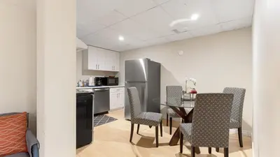 a kitchen with a table and chairs and a refrigerator at Finished 2 BR Apartment in an Upscale Area of Ajax in Ajax