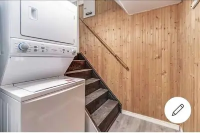 a laundry room with a washer and a staircase at Affordable stay near the OPG TV and parking in Pickering