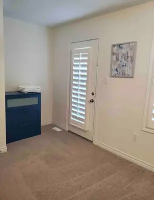 an empty room with a door and a blue dresser at Modern & Cozy Kawartha Getaway in Kawartha Lakes
