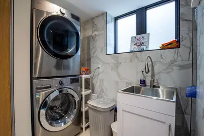 a bathroom with a washing machine and a sink at N7 Castle Green Retreat-Hot Tub in Toronto