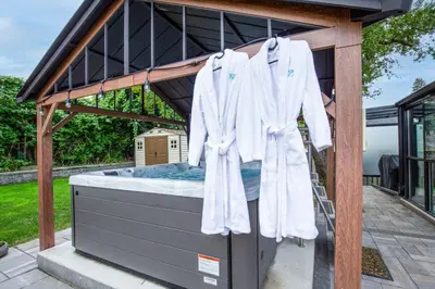 a white robe is hanging on a bed at N7 Castle Green Retreat-Hot Tub in Toronto