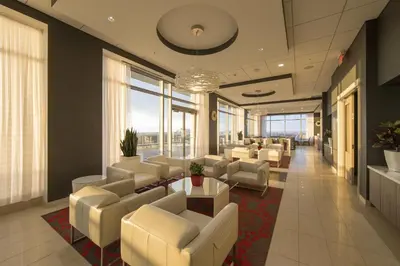 a waiting room with white chairs and tables and windows at Liberty Suites in Thornhill