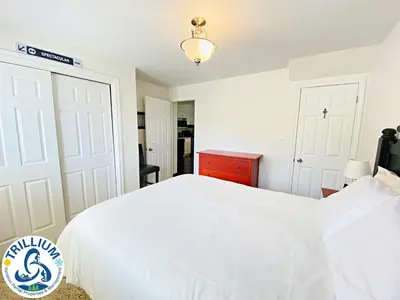 a bedroom with a white bed and a red dresser at Blue Mountain Suites in Blue Mountains