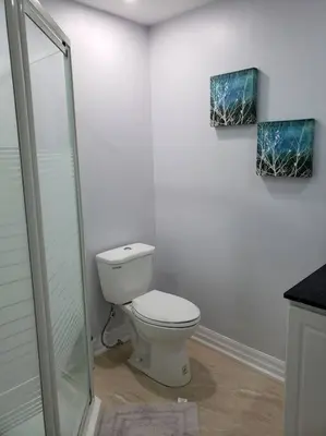 a bathroom with a toilet and a glass shower at Luxurious 1BR - 1BA Apt Modern Bright with free parking-pc in Brampton