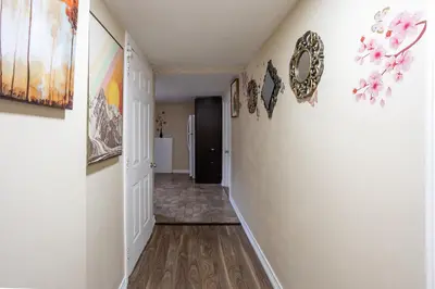 a hallway with white walls and wooden floors at Private room with TVnetflix and free parking in Pickering