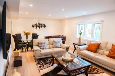 a living room with a couch and a table at Riverfront Cottage Sauna Canoe Included Kids Playroom Nature Escape in Wasaga Beach