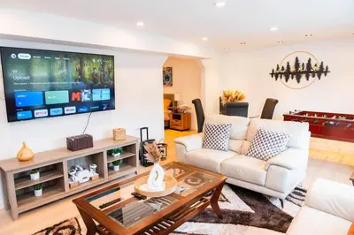 a living room with a white couch and a tv at Riverfront Cottage Sauna Canoe Included Kids Playroom Nature Escape in Wasaga Beach
