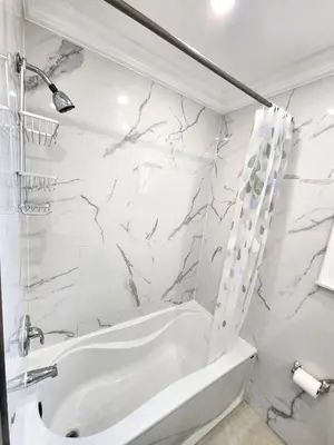 a white bathroom with a tub and a shower at Toronto Uptown 3 - Bus to Downtown in Toronto