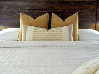 a bed with white sheets and pillows on it at Modern Townhome at Wintergreen Sauna Steps from Blue Mountain Village in Blue Mountains