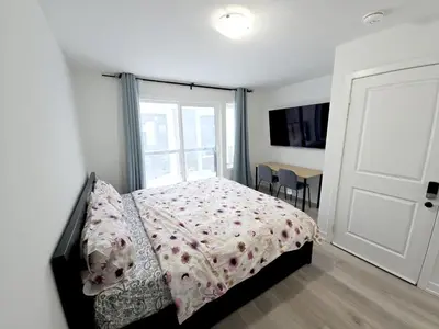 a bedroom with a bed and a window and a table at King Bed TV Private Ensuite Retreat Bathroom or Economical Double Bed Room in Toronto