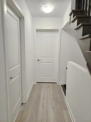 an empty hallway with a white door and stairs at King Bed TV Private Ensuite Retreat Bathroom or Economical Double Bed Room in Toronto