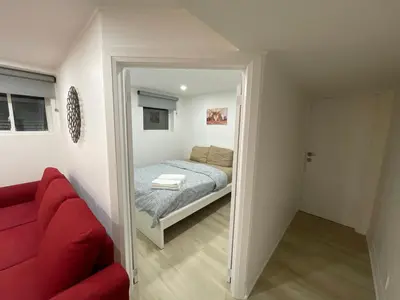 a bedroom with a bed and a red couch at Executive Apartment - 2BDR Parking Self-check in - Walkout basement Lower Unit in Mississauga