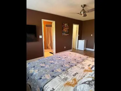 a bedroom with a large bed with a floral bedspread at Beautiful Master bedroom unit with private washroom in Mississauga