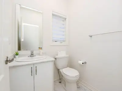 a white bathroom with a toilet and a sink at Stylish Home in Waterdown in Hamilton