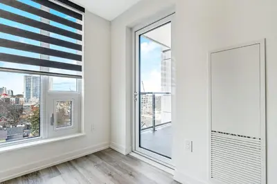an empty living room with large windows at Luxury 1BR King Bed Unit - Private Balcony in Kitchener