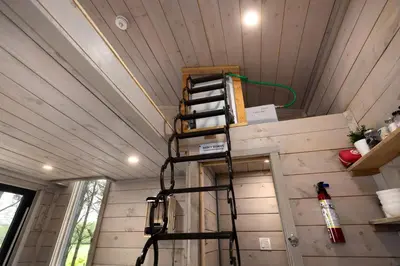 a tiny house with a ladder in the ceiling at Little Cabin in the Pines in Chatsworth