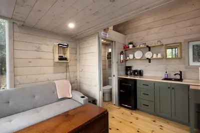 a kitchen with a couch in a tiny house at Little Cabin in the Pines in Chatsworth