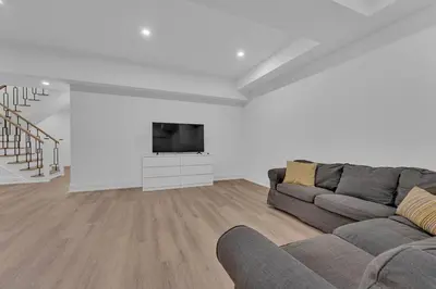 a living room with a couch and a flat screen tv at Sherkston Oasis - Hot Tub Soaks & Luxurious Escape in Port Colborne