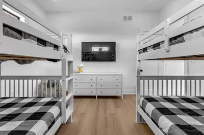 two bunk beds in a room with a tv at Sherkston Oasis - Hot Tub Soaks & Luxurious Escape in Port Colborne