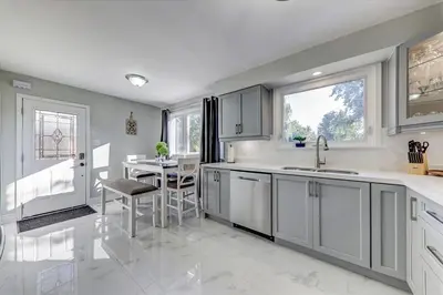 a kitchen with a sink and a table in it at Stunning 7 Br RougeView Home with 2 Kitchens, 5 Bathrooms, Amazing Backyard & 8-Car Parking in Toronto