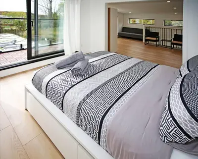 a large bed in a bedroom with a balcony at Sherkston Bliss - Hot Tub Soaks & Backyard BBQ Fun in Port Colborne