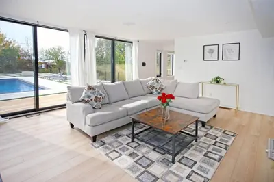 a living room with a couch and a table at Sherkston Bliss - Hot Tub Soaks & Backyard BBQ Fun in Port Colborne