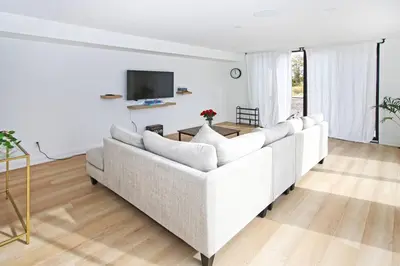 a living room with a white couch and a tv at Sherkston Bliss - Hot Tub Soaks & Backyard BBQ Fun in Port Colborne