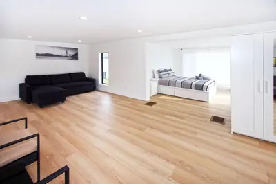 a living room with a couch and a bed at Sherkston Bliss - Hot Tub Soaks & Backyard BBQ Fun in Port Colborne