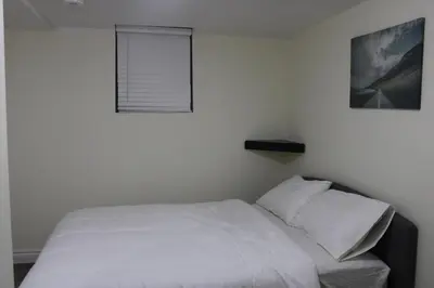 a white bed in a bedroom with a window at Comfyhome in Vaughan