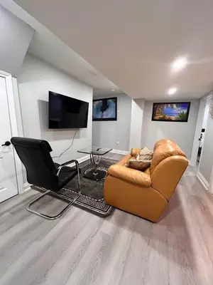 a living room with a couch and a chair and a table at SUITE A 2 Bedroom Apartment in Brampton