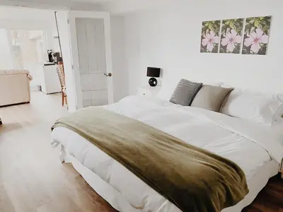 a white bedroom with a large white bed in it at Irish Mountain Suites in Meaford