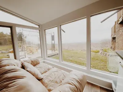 a living room with a couch and large windows at Irish Mountain Suites in Meaford