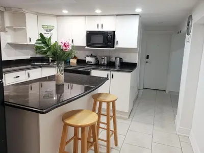 a kitchen with a counter and two stools at Tidy Private Rooms with Full Kitchen in Toronto