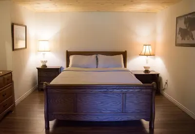 a bedroom with a bed with two lamps on both sides at The Nest in the Forest Bed and Breakfast (Hot tub and Sauna) in Lakefield