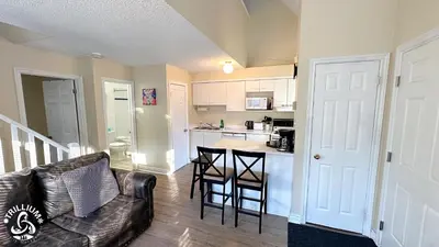 a living room with a couch and a kitchen at Mountainview Loft at North Creek Resort in Blue Mountains