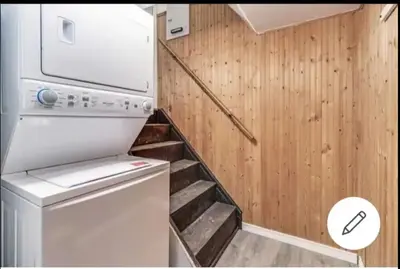 a small laundry room with a washer and a staircase at Cozy room near Pickering OPG in Pickering