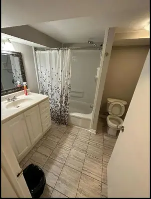 a bathroom with a shower and a toilet and a sink at Cozy room near Pickering OPG in Pickering