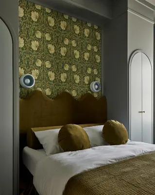 a bedroom with a bed with a headboard and a wall at Hotel Julie in Stratford