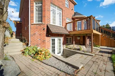 a brick house with a porch and a balcony at Cozy Lovely Ravine facing Suite. in Mississauga