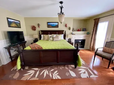 a bedroom with a bed and a television and a fireplace at Explorer House Bed & Breakfast in Niagara on the Lake