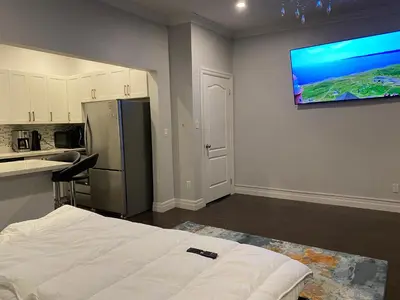a kitchen with a bed and a television on a wall at Downtown apartment 2-3 people in Bowmanville