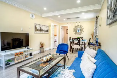 a living room with a blue couch and a table at 2 Bedroom East-York bungalow in Toronto
