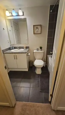 a bathroom with a toilet and a sink and a mirror at Modern 2BR Townhouse w Patio & Free Parking Family & Work Stays in Toronto