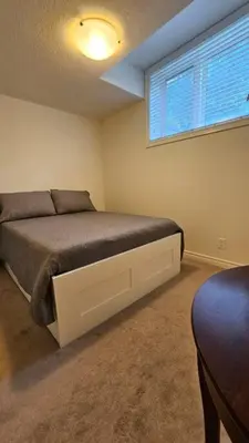 a bedroom with a bed with a large window at Modern 2BR Townhouse w Patio & Free Parking Family & Work Stays in Toronto
