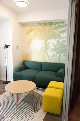 a living room with a green couch and a table at The Laundry Rooms Station Park Kitchener in Kitchener